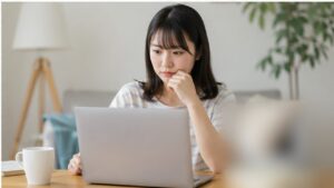 ノートパソコンで電子書店を比較する日本人女性