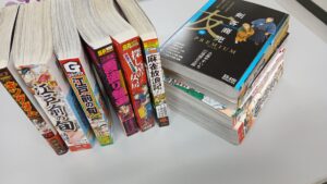 机の上に複数の漫画単行本やコミックを並べた様子