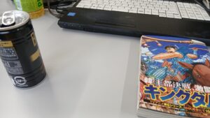 パソコンのある机でキングダムの漫画単行本を読むイメージ