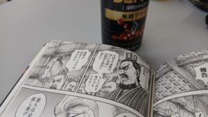 コーヒーを飲みながら紙の漫画を開いて読むイメージ